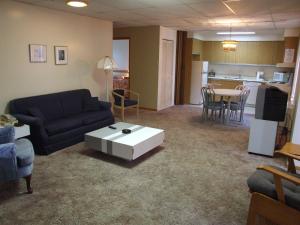 a living room with a couch and a table at Hotellerie Jardins de Ville in Sherbrooke