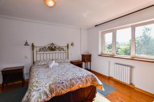 a bedroom with a bed and two windows at Casona con gran jardín in Camargo