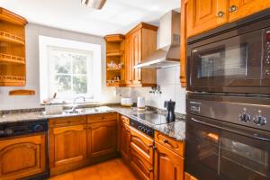 a kitchen with wooden cabinets and a stove top oven at Casona con gran jardín in Camargo