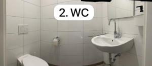 a white bathroom with a toilet and a sink at Haus Else in Schüttorf