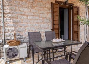 a patio with a table and chairs and a heater at cozy house in Vlikhón