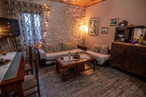 a living room with a couch and a table at cozy house in Vlikhon