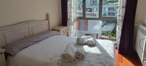 a bedroom with a bed with towels on it at Apartamento Cosy. Bonito y Acogedor Duplex in Latas +32 photos