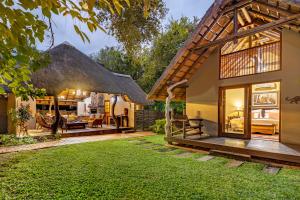 馬里蘭的住宿－Mhlati Guest Cottages，茅草屋顶和庭院的房子