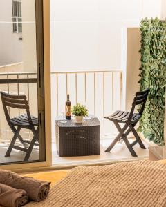 balkon z 2 krzesłami i stołem z butelką wina w obiekcie Modern Comfort - 2BR Apartment center of St Julians & Paceville w mieście Paceville