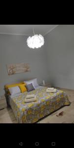 1 dormitorio con 1 cama con manta amarilla y luz en Apartment Miriade, en Balestrate