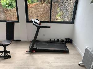 a room with a treadmill in a room with two windows at Casa do Til, central Funchal in Funchal