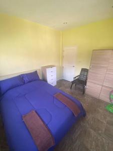 a bedroom with a blue bed and a chair at Thai style 3 bedroom pool house. in Khao Lak