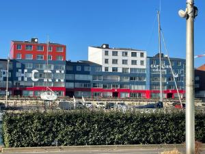 eine Gruppe von Gebäuden vor einem Hafen in der Unterkunft L'Escale ensoleillée, 2 pièces sur le Port proche Juno Beach in Courseulles-sur-Mer