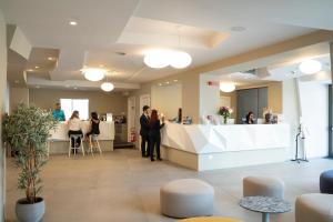 a lobby with people standing at a counter at Hotel Malavoglia in Acitrezza +37 photos