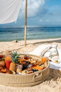 kosz z jedzeniem na piaszczystej plaży w obiekcie Villa Cambier by muse villas w mieście Le Morne