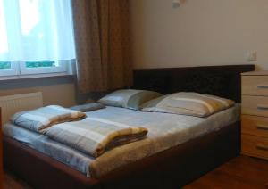 un letto con due cuscini sopra in una camera da letto di Pokoje przy lesie a Stegna Altre 5 foto