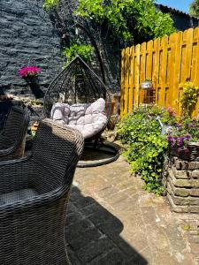 a garden with two wicker chairs and a swing at Ferienwohnung Terrassenblick in Zülpich