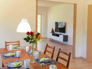 une salle à manger avec une table et un vase de fleurs dans l'établissement Ferienhaus Maring, à Maring-Noviand