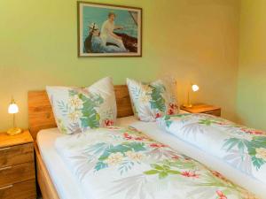 - un lit avec deux oreillers et une photo sur le mur dans l'établissement Ferienhaus Maring, à Maring-Noviand