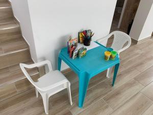 una mesa azul y 2 sillas en una habitación en ELVIS Apartman, en Pápa