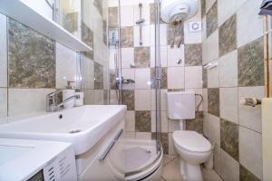 a bathroom with a white toilet and a sink at Spacious apartment 50 m from the beach in Postira