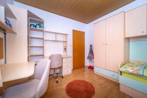 a childs bedroom with a desk and a bed at Spacious apartment 50 m from the beach in Postira
