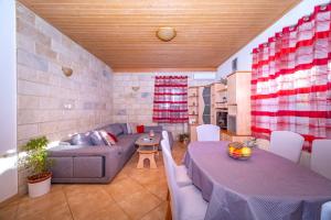a living room with a couch and a table at Spacious apartment 50 m from the beach in Postira