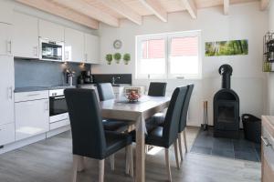 a kitchen and dining room with a table and chairs at 9200 Seerose 4 in Süssau