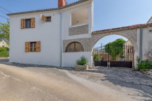 an external view of a white house with a gate at Holiday House Lena in Baderna