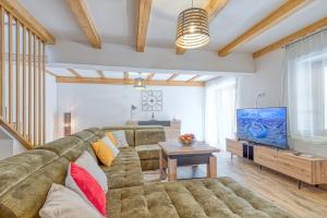 a living room with a large couch and a tv at Holiday House Lena in Baderna