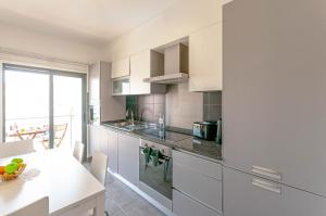 una cucina con armadi bianchi e piano di lavoro bianco di Almond Apartment by OCvillas ad Albufeira