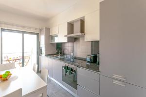 a kitchen with white cabinets and a white counter top at Almond Apartment by OCvillas in Vale de Pedras