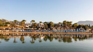 a beach with chairs and umbrellas and the water at Costa Bitezhan Hotel - All Inclusive in Bitez
