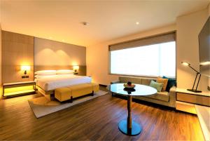 a hotel room with a bed and a couch at Courtyard by Marriott Vadodara in Vadodara