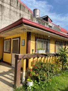 una casa gialla con una recinzione di fronte di Maria Kulafu Studio Apartment Kinamaligan- Beside Eglin Gas FREE Wifi a Masbate