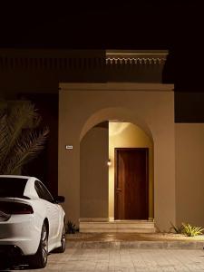 a white car parked in front of a building with a door at one bedroom villa in Salalah