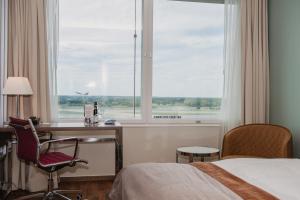 a hotel room with a bed and a desk and a window at Clarion Hotel Arlanda Airport Terminal in Arlanda