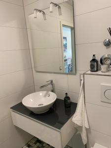 uma casa de banho com um lavatório e um espelho num balcão em Rüngsdorf em Bonn