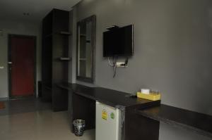 a room with a tv on the wall and a refrigerator at Khaoyai Terrazzo in Mu Si