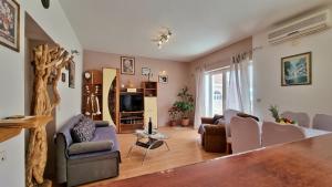 a living room with a couch and chairs and a tv at Apartment Gogo Duce in Duće