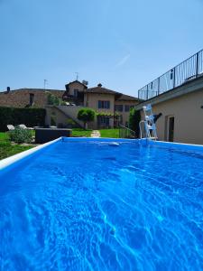 una gran piscina azul con una silla en un patio en Cascina BELLONUOVO, en Alba