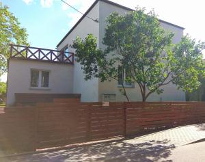 una casa con una valla de madera delante de ella en Pokoje przy lesie, en Stegna