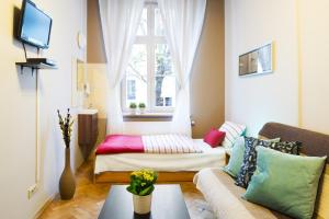 a living room with a couch and a window at Apartamenty i Studia HERBARIUM in Krakow