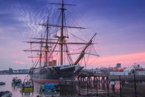 a large ship docked in a harbor with a sunset at City Haven Luxurious 3-Bed Retreat in Portsmouth