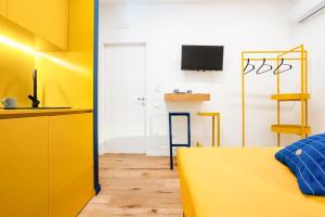Cette chambre dispose d'un lit jaune et d'une cuisine. dans l'établissement Archi Rooms Boutique, à Salerne