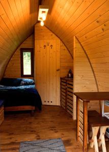 Domek Wilcza Wola 2 في Górzanka: غرفة نوم في كابينة خشب بها سرير ونافذة