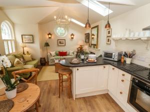 a kitchen with a table and a living room at The Coach House at Pendower House in Fowey