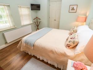 a bedroom with a large bed with white sheets at The Coach House at Pendower House in Fowey