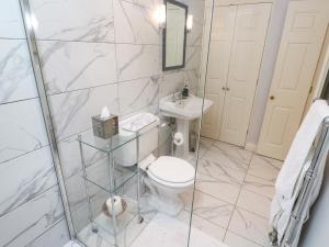 a bathroom with a toilet and a sink and a shower at The Coach House at Pendower House in Fowey +23 photos