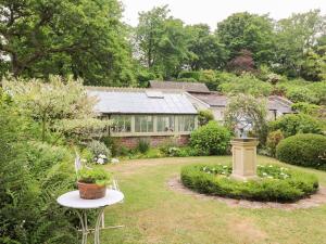 a garden with a house with a glass roof at The Coach House at Pendower House in Fowey