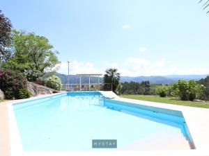 uma piscina numa villa com montanhas ao fundo em MyStay - Quinta Porto Ferrado em Santa Cruz do Douro