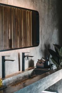 a bathroom sink with two faucets and a mirror at DABA - Designer Villas in Perenenan - Beach 600M in Canggu