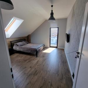 a attic bedroom with a bed and a window at Premium House Osztynek in Olsztynek