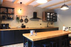 Una cocina con gabinetes negros y encimeras de madera. en Wild Hunts Lodge Retezat, en Raul Mare